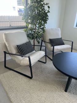 Pair of off-white arm chairs with black metal accents