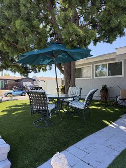 Glass patio table in perfect condition, with its umbrella and four chairs.