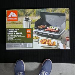 NEW IN SEALED BOX, THE ULTIMATE IN OUTDOOR COOKING, 20,000 BTU,S OF COOKING POWER "OZARK TRAIL" DUAL BURNER, TABLE TOP GRILL / STOVE W/ CAST IRON SKIL