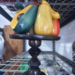 vintage, hand-carved wooden fruit displayed on a wooden stand.