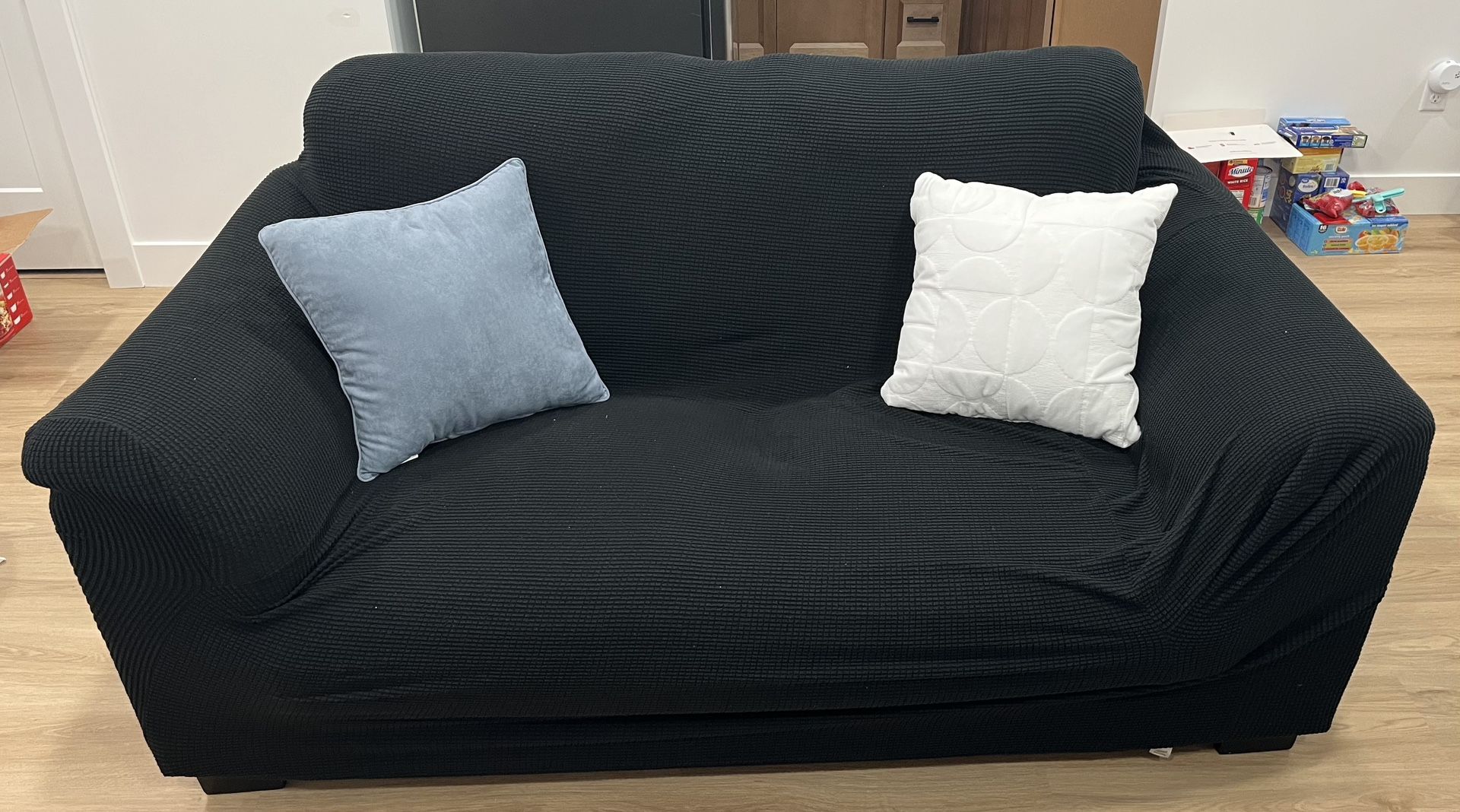 Black loveseat couch with new throw pillows
