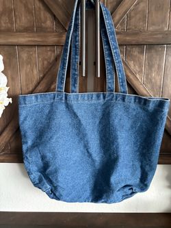 blue denim tote bag features a spacious slouchy design with classic double shoulder straps
