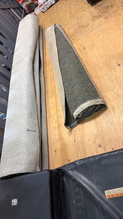 Black Rolls of carpet and one with Floral Pattern