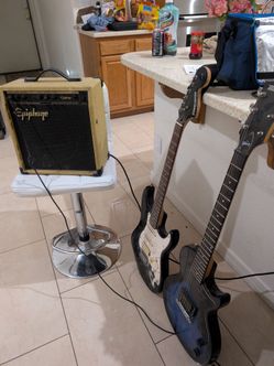 Fender and Gibson guitars with amp
