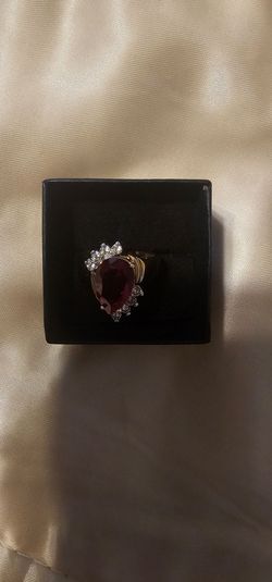 Gold ring with red gemstone and clear stones