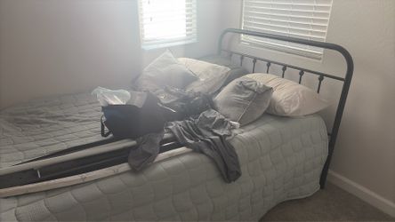 Metal bed frame with mattress and bedding