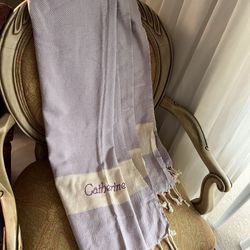 a personalized lilac and yellow striped Turkish cotton beach towel with fringe, also known as a peshtemal or fouta towel. 