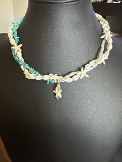 A beautiful necklace made of shells and artificial turquois
