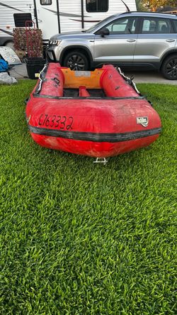 red Achilles inflatable boat with a black rubber rub strake along the side.Achilles boats are often constructed from durable Hypalon material, known f