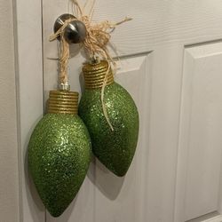 large, green, glitter light bulb Christmas ornaments. They are designed to mimic classic C9-style light bulbs 