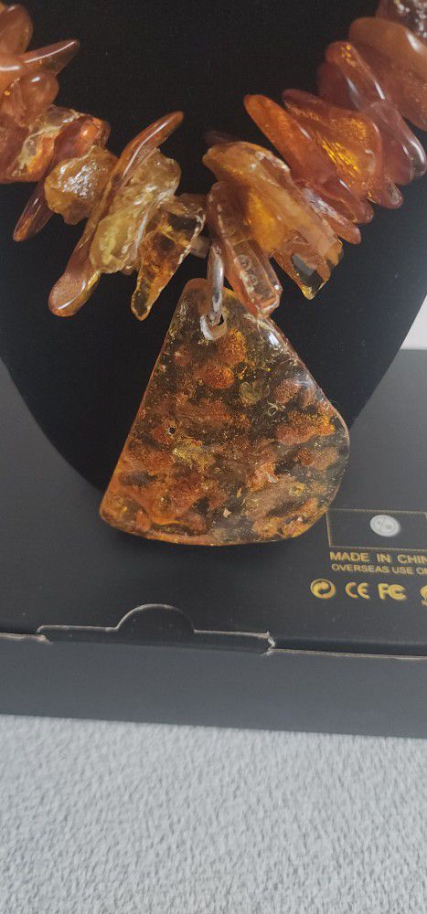 long amber necklace has a medallion