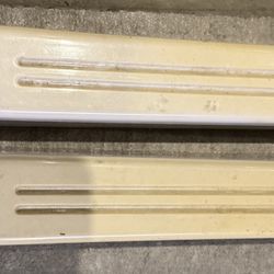 Two plastic feet and knob from a vintage floor fan.