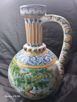 Spanish Talavera ceramic jug features a vibrant landscape design