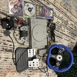 PS1 with steering wheel, pedals, controller, cabels, and four games