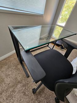 Desk with glass top and chair.