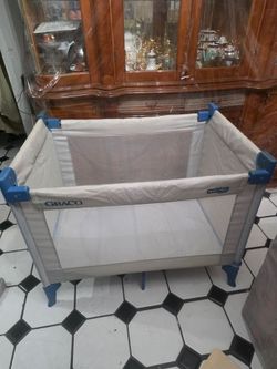 used Graco Pack 'n Play portable playard with a light gray fabric body, white mesh sides,
