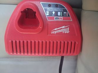 red Milwaukee 48-59-2401 M12 Lithium-Ion 12-Volt Battery Charger designed for compact power tool batteries