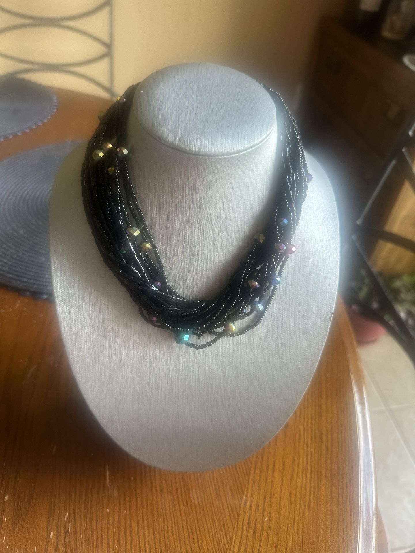 Bold multi-strand black necklace choker with blue, pink accents.