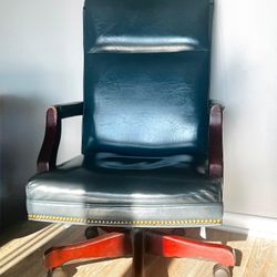 Dark leather executive revolving chair with wood arms