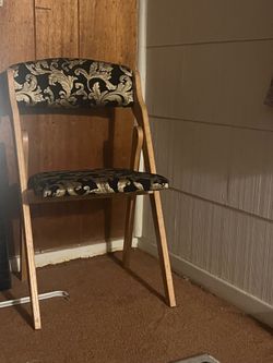 Two black and gold foldable side chairs