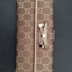 Brown designer wallet with signature pattern.