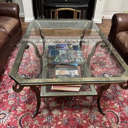 Glass coffee table with brass legs.