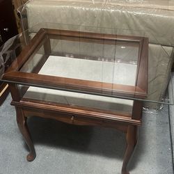 An old wooden table with a glass lid