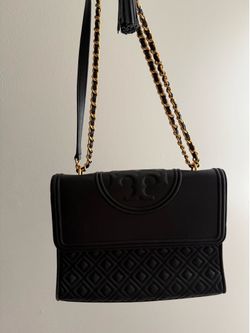 This black Tory Burch Fleming Convertible Shoulder Bag is crafted from leather with a distinctive quilted pattern.