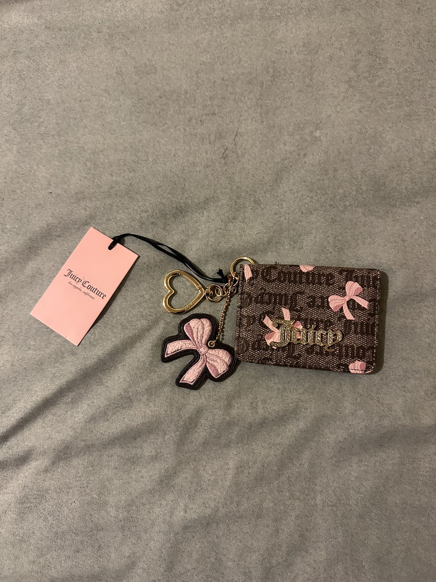 NWT Juicy Couture Pink Card Holder with Heart Keychain Fob NWT Juicy Couture Pink Card Holder with Heart Keychain Fob. Features a bow pattern and a h