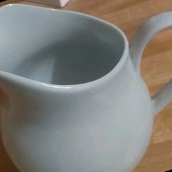 The item is a ceramic pitcher, likely a creamer or milk jug.