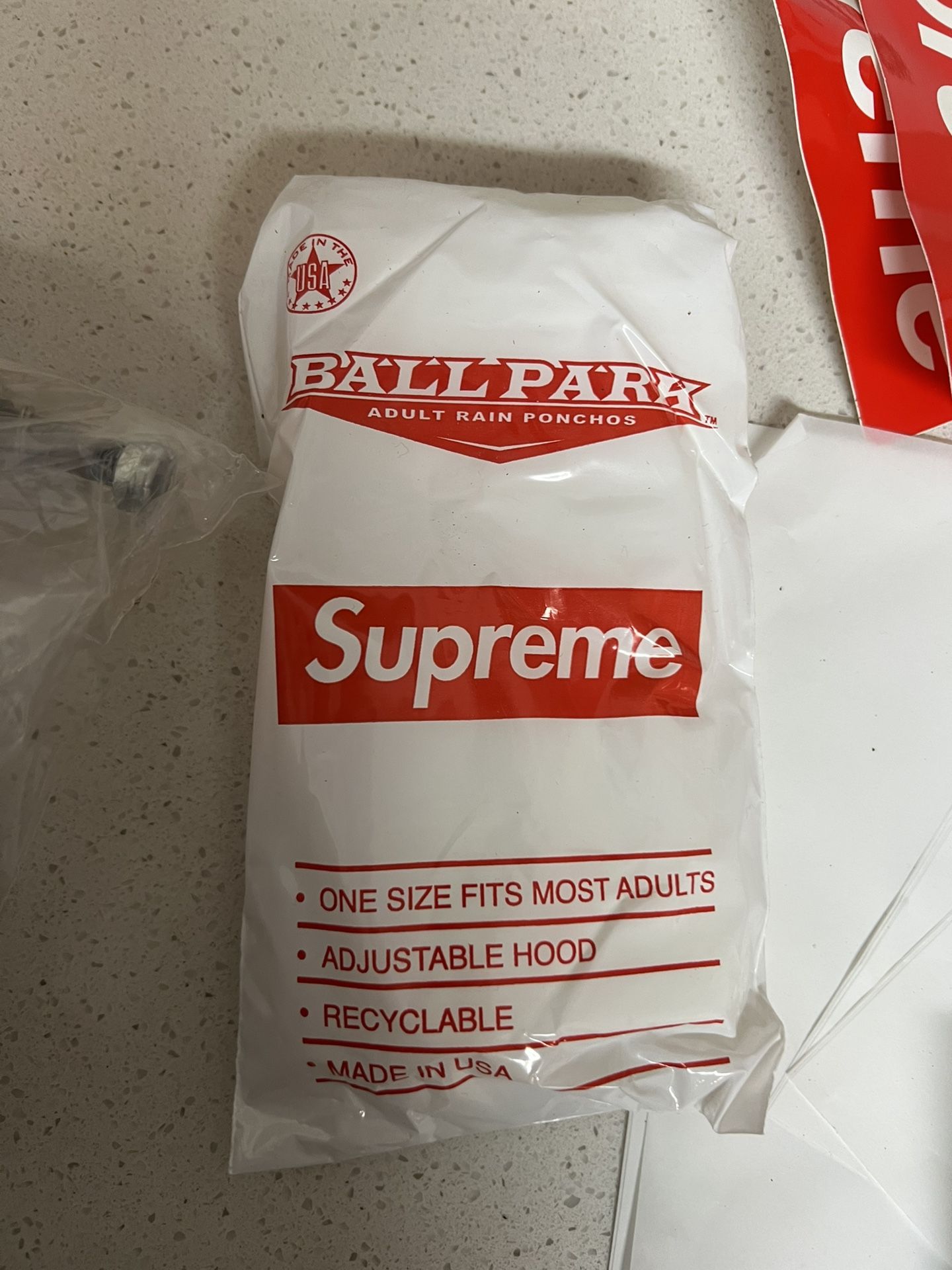 Supreme Ballpark Rain Poncho in white and red.