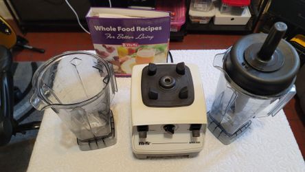 VITAMIX SUPER 5000 BLENDER WITH ACCESSORIES 2 GLASSES AND A RECIPE BOOK IN WHITE COLOR.