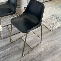 2 CB2 Saddle Counter Chairs 
