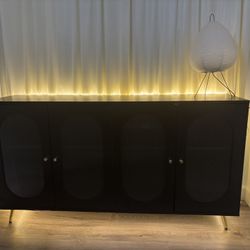 Long black accent sideboard cabinet with fluted glass doors and gold details