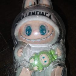 Custom Labubu Plush Wearing  mint green coat, teal eyes, and a small green creature it is holding. 