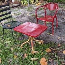 One Metal Table Two Metal Chairs One Red One Black