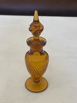 Vintage 1930s-1950s amber glass perfume bottle with twisted optic pattern and stopper.