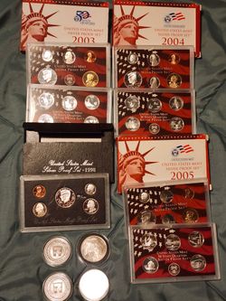 Four 1 oz silver coins and four US silver proof sets