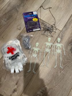 Assorted Halloween bundle includes: *three glow-in-the-dark plastic skeletons *a silver-tone metal spider web necklace with black accents *a new-in-pa