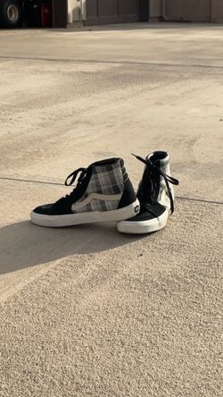 Vans Sk8-Hi high-top sneakers with a black, gray, and white plaid/check pattern.
