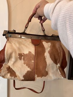 Cowhide and leather purse with shoulder strap has unique hardware has wear on both sides 