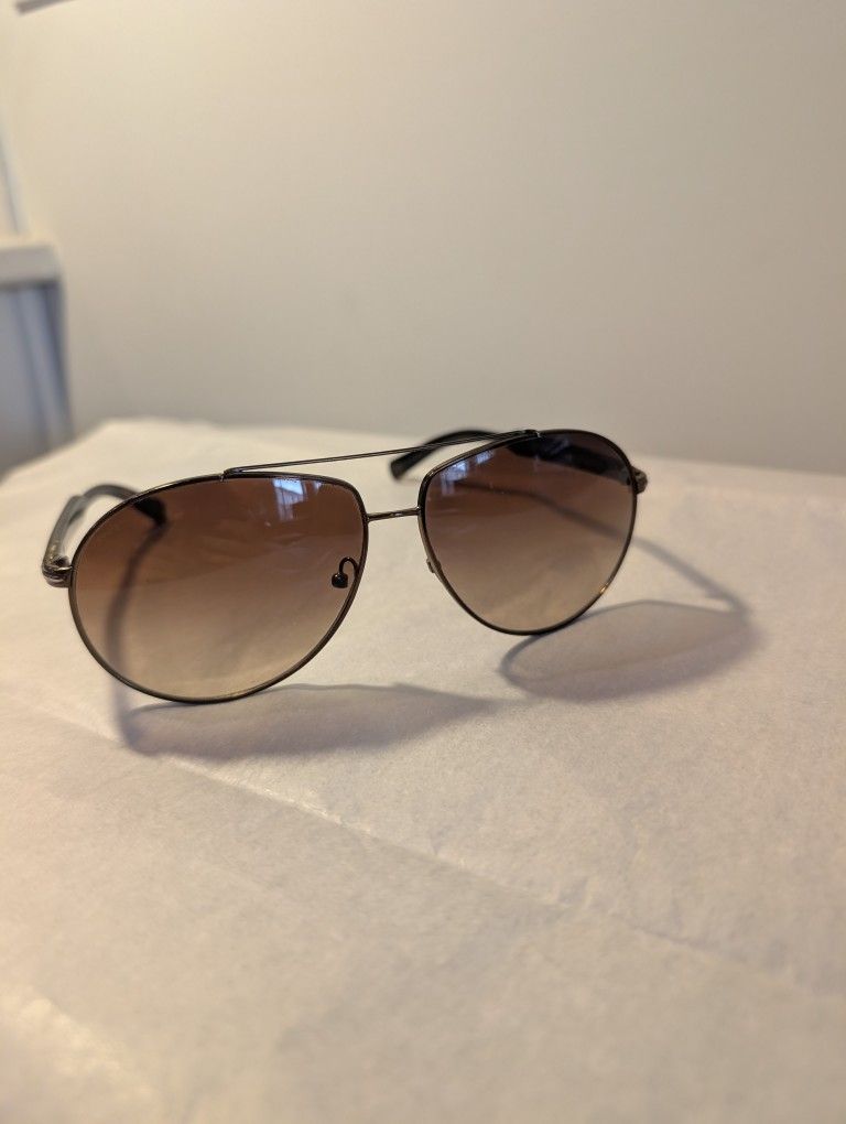 Prada SPR 50N aviator sunglasses with a gunmetal frame and brown gradient lenses.