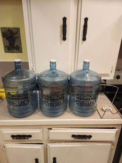 5 gallon Carlsbad Alkaline Water Bottles (3) with lids, stand, and leak proof spout.
