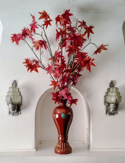 brown and red vase mantle piece with brown and red leaves