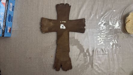 Cruz estilo madera  y metal con figura de vaqueros y caballos.