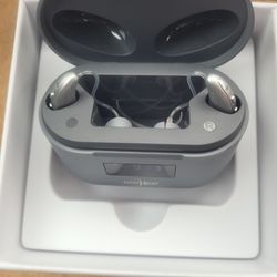 Ultra BTE OTC Hearing Aids in their charging case. 