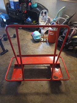 red steel drywall cart (also known as a panel carrier or sheet material dolly), which is designed to transport large sheets of drywall, plywood, or pa