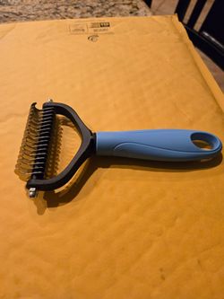 A dual sided pet dematting and deshedding undercoat rake new in package