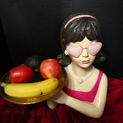 Retro-inspired design from the 1960s, including a flip hairstyle, heart-shaped sunglasses, and a pearl necklace.