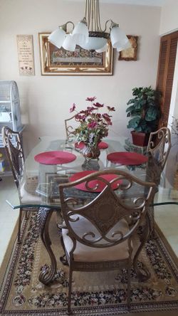 Beautiful dining table set glass top 4 chairs . wrought iron plus wine buffet . $475. Ocala shores.